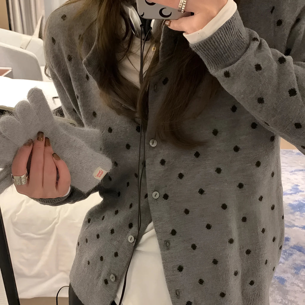 Women's grey dot pattern knitted cardigan with crochet flower detailing on mannequin