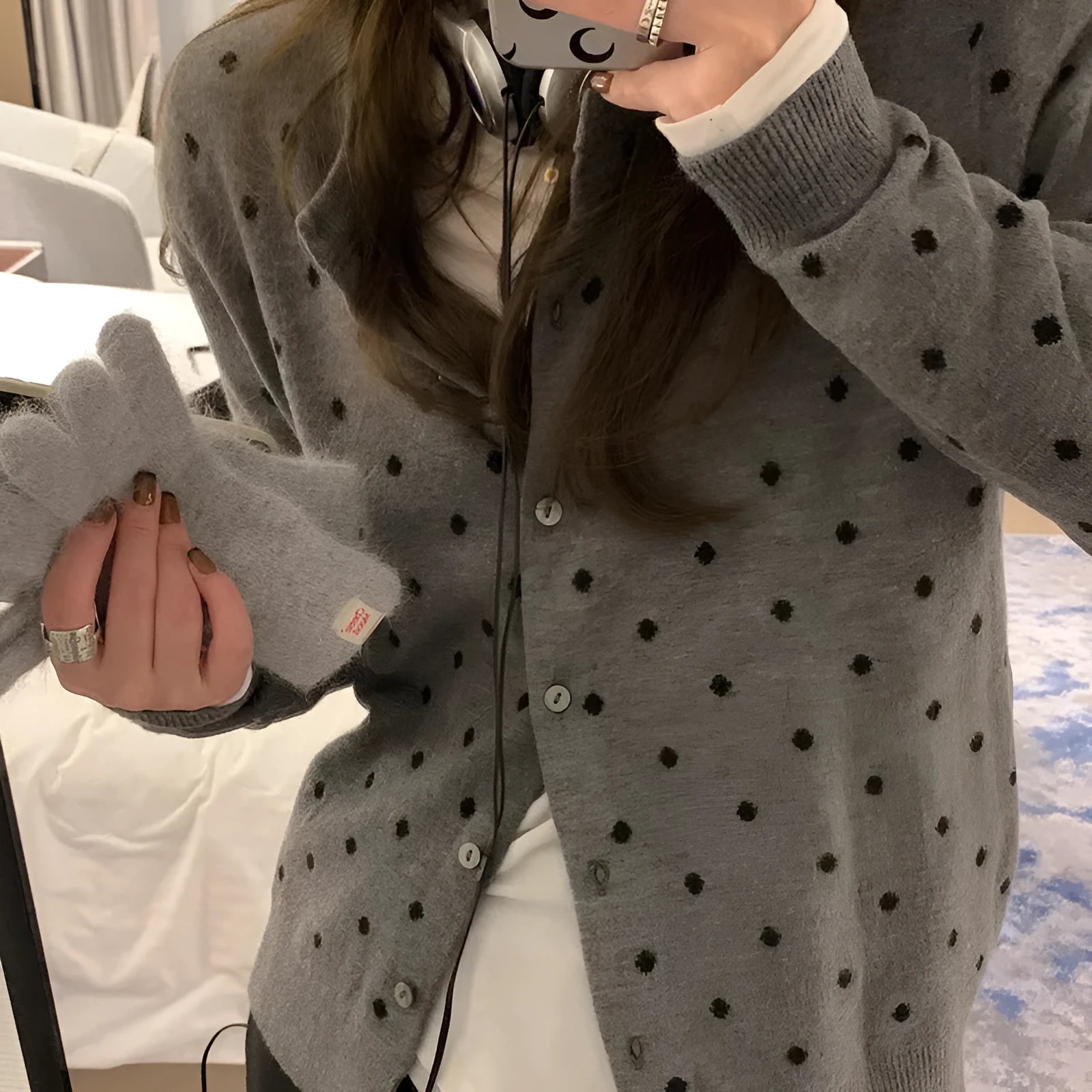 Women's grey dot pattern knitted cardigan with crochet flower detailing on mannequin