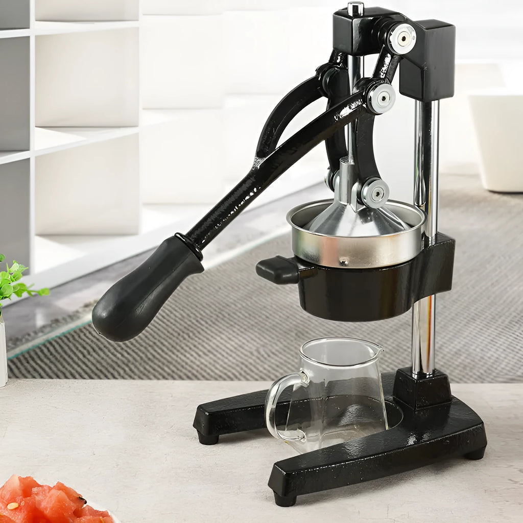 Black cast iron manual citrus juicer with stainless steel cone and lever, 40cm tall on a table.