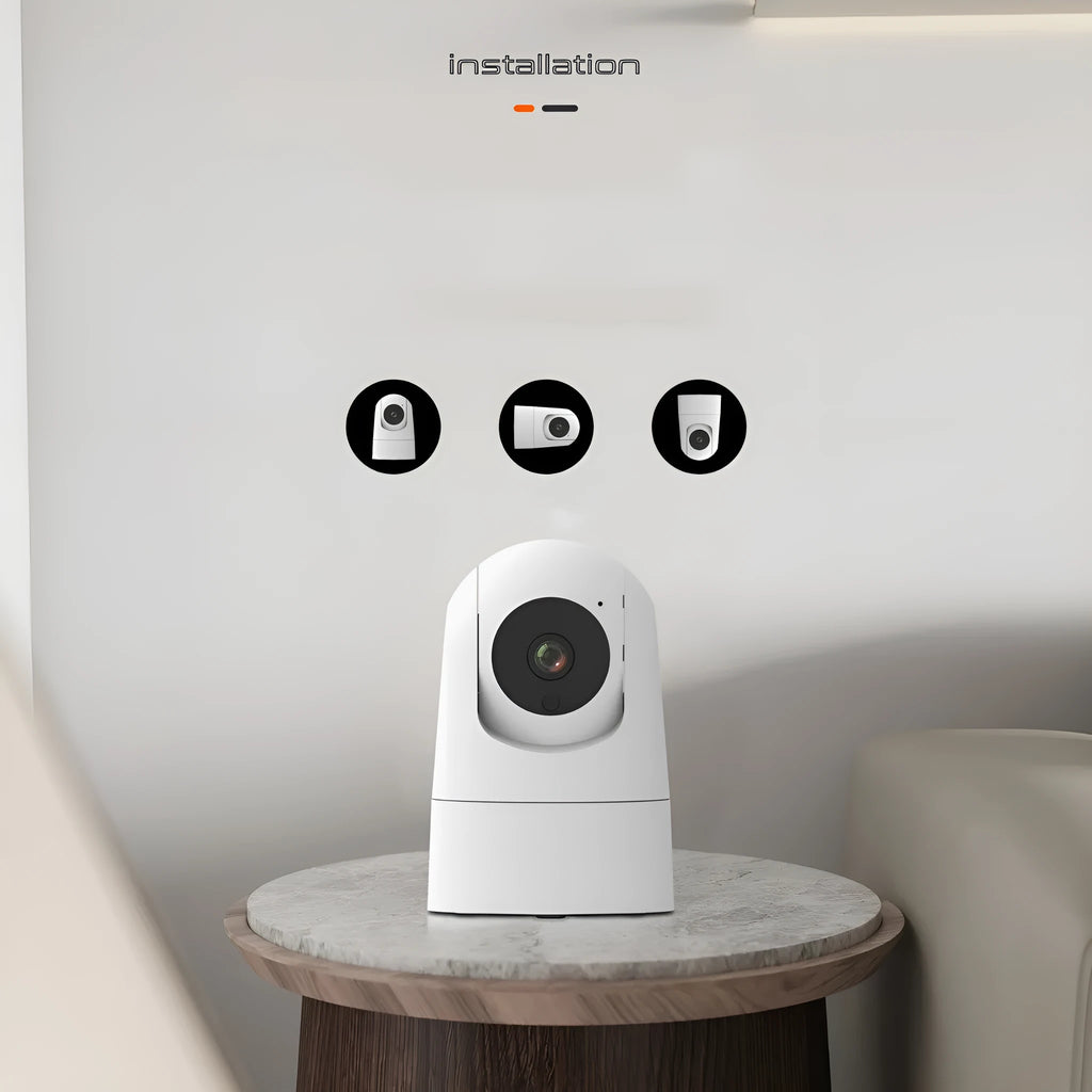 White square indoor security camera with lens and status light on front, shown next to its power adapter.