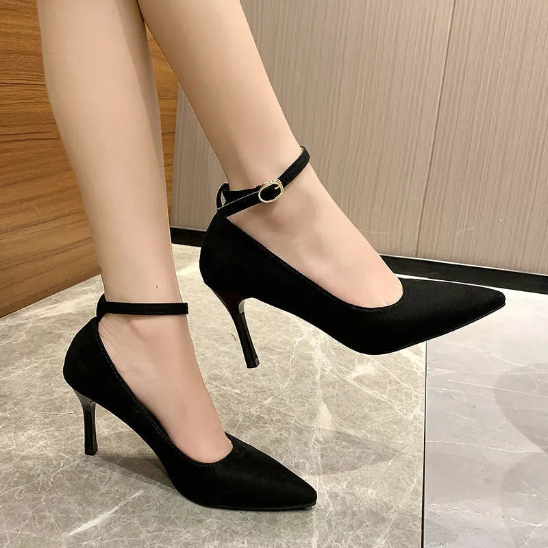 Women's black stiletto pump shoes with a buckle decoration on the upper