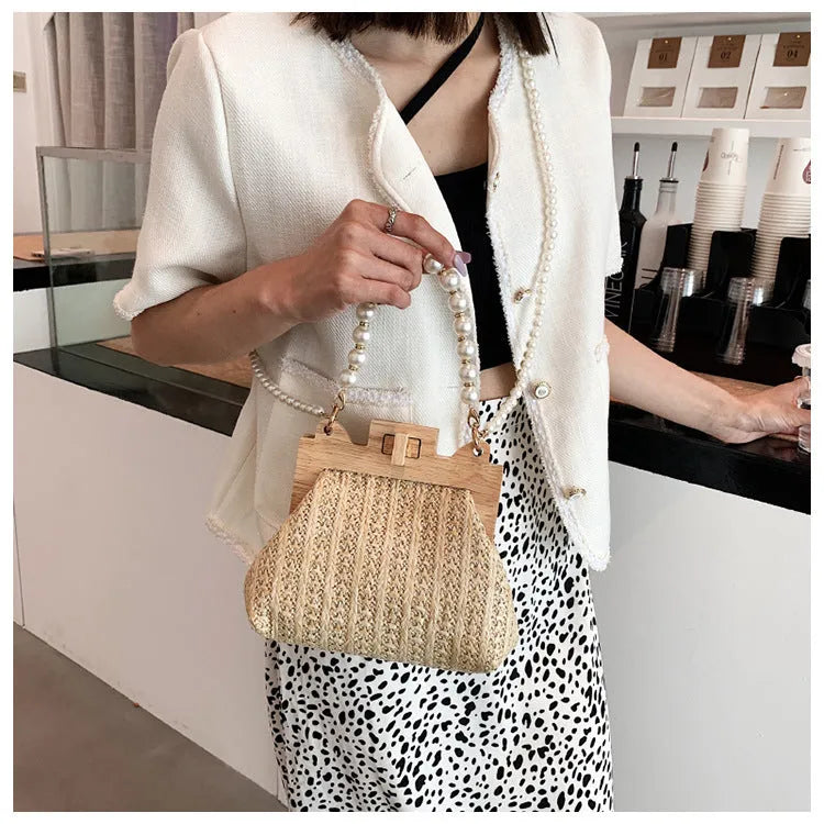 Women's woven straw shoulder bag with pearl chain details showing interior organisation compartments