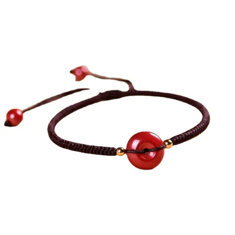 Traditional Chinese cinnabar bracelet with heart-shaped centrepiece and peace buckle clasp on coloured rope cord