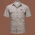 Men's army green cotton work shirt with short sleeves and non-iron finish on a hanger.