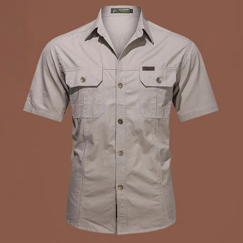 Men's army green cotton work shirt with short sleeves and non-iron finish on a hanger.