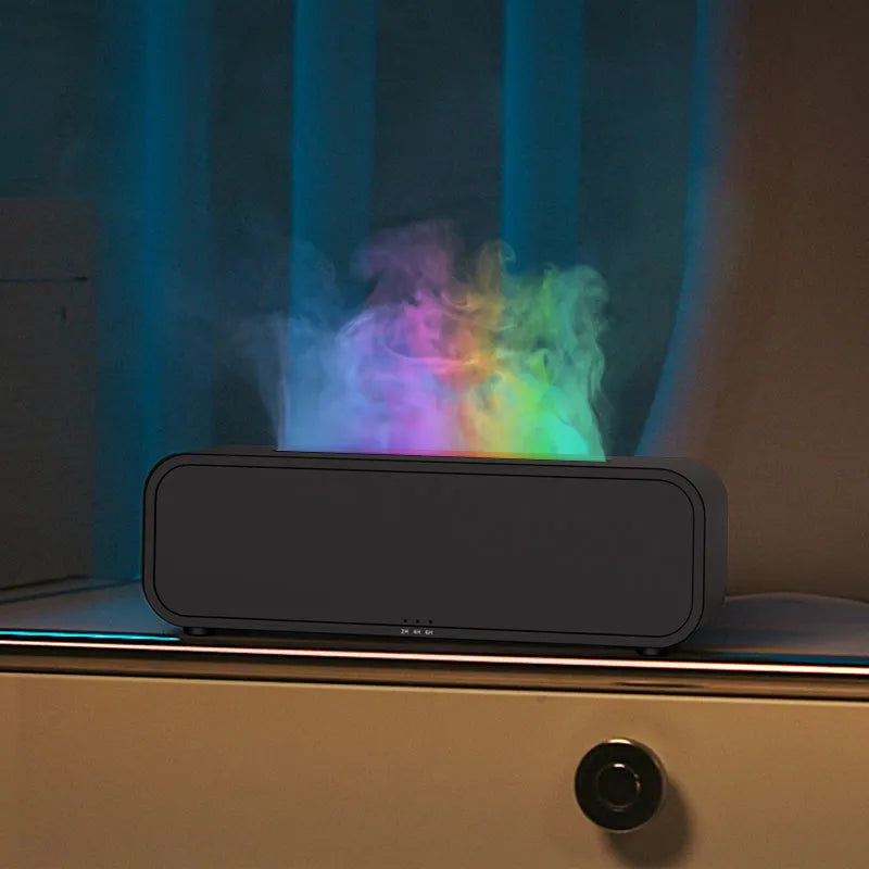 White aroma diffuser with colour-changing lights on a wooden table next to its remote control.