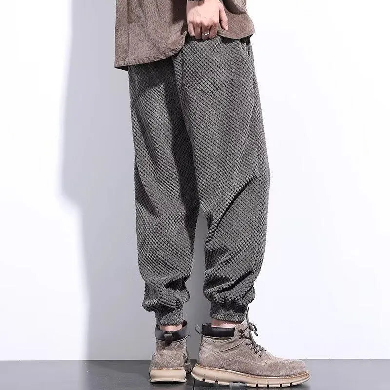 Men's grey ankle-tied straight leg sweatpants laid flat, showing casual sports design.