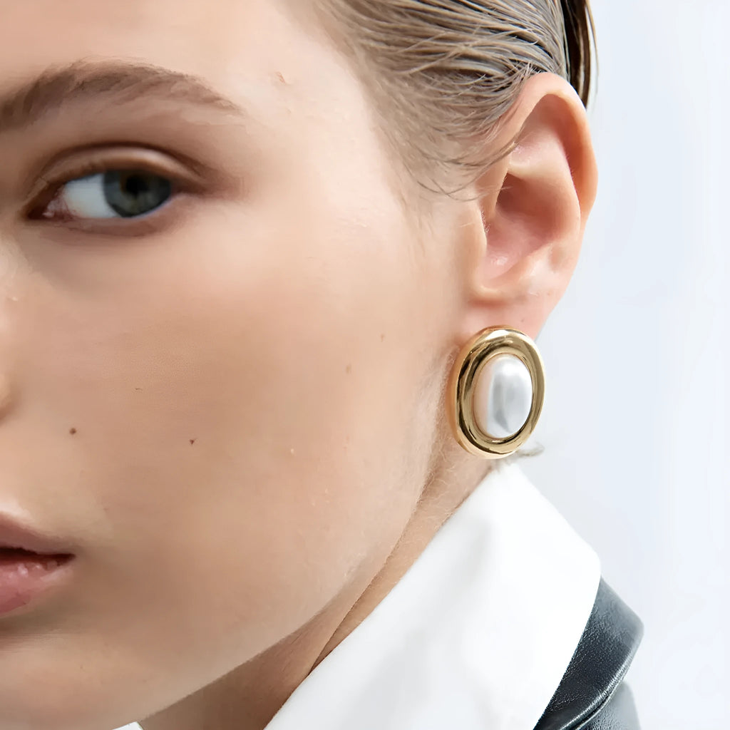 A pair of gold-colour stainless steel ear studs with a vintage pearl centre and butterfly clutch backs.