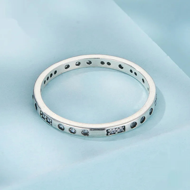 Close-up of a women's oxidised black silver alloy ring with an etched 'I love you' moss password design on a simple band.