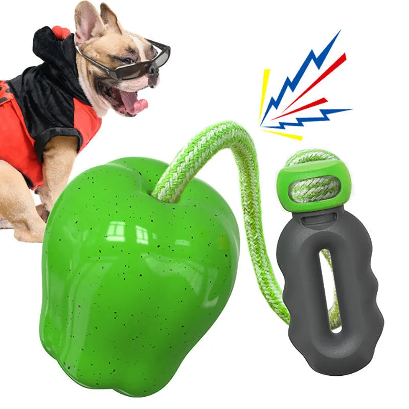 Green apple-shaped dog molar toy with dropping ball mechanism on white background
