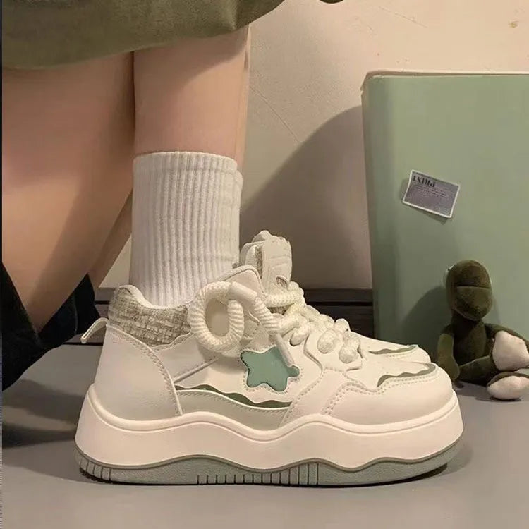 Women's green patent leather platform sneakers with round toe and lace-up front on a rubber sole.