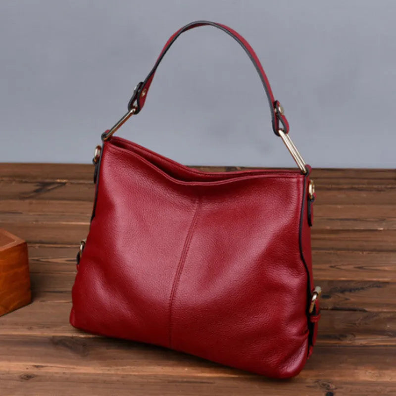 Genuine leather vertical square crossbody bag in black colour with visible stitching and multiple compartments.