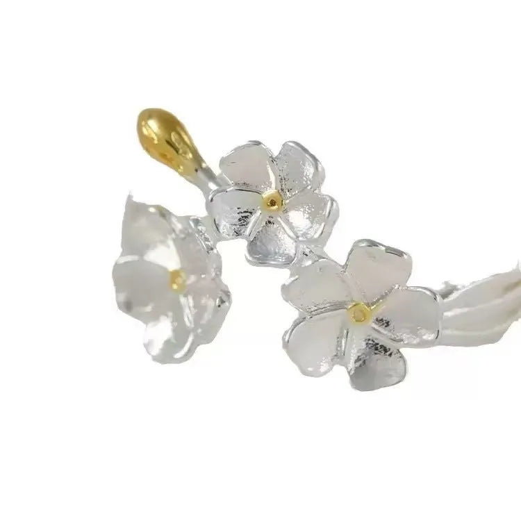 Three-dimensional zinc alloy jasmine flower ring with open mouth design on a finger.