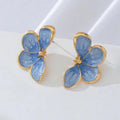 Three-dimensional flower earrings in blue and red colour options on a neutral background