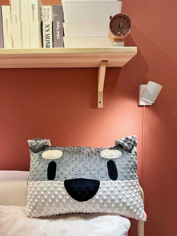Grey schnauzer and white West Highland puppy decorative throw pillows on a sofa.