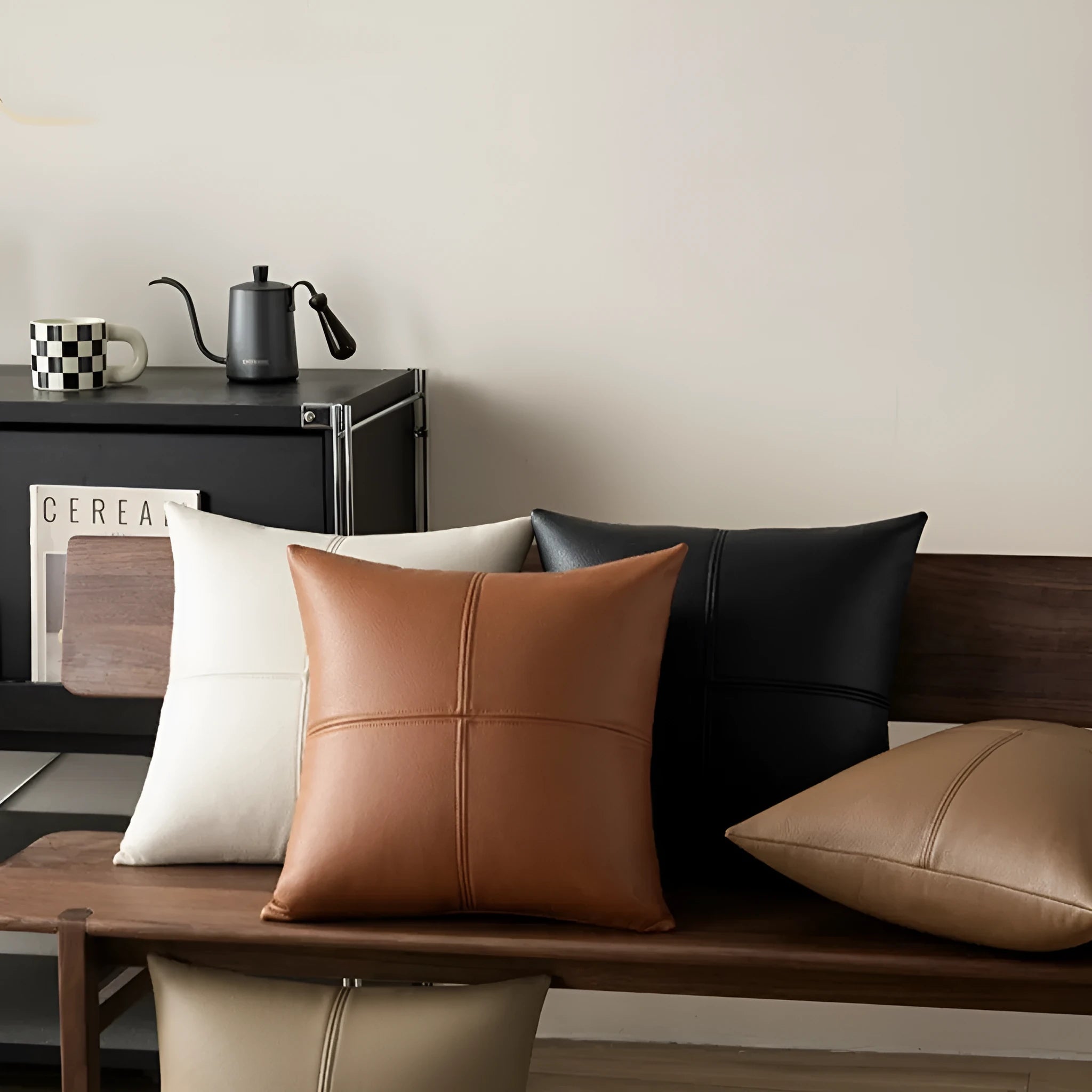 A solid colour soft cowhide leather pillow cover on a sofa, shown in a neutral tone.