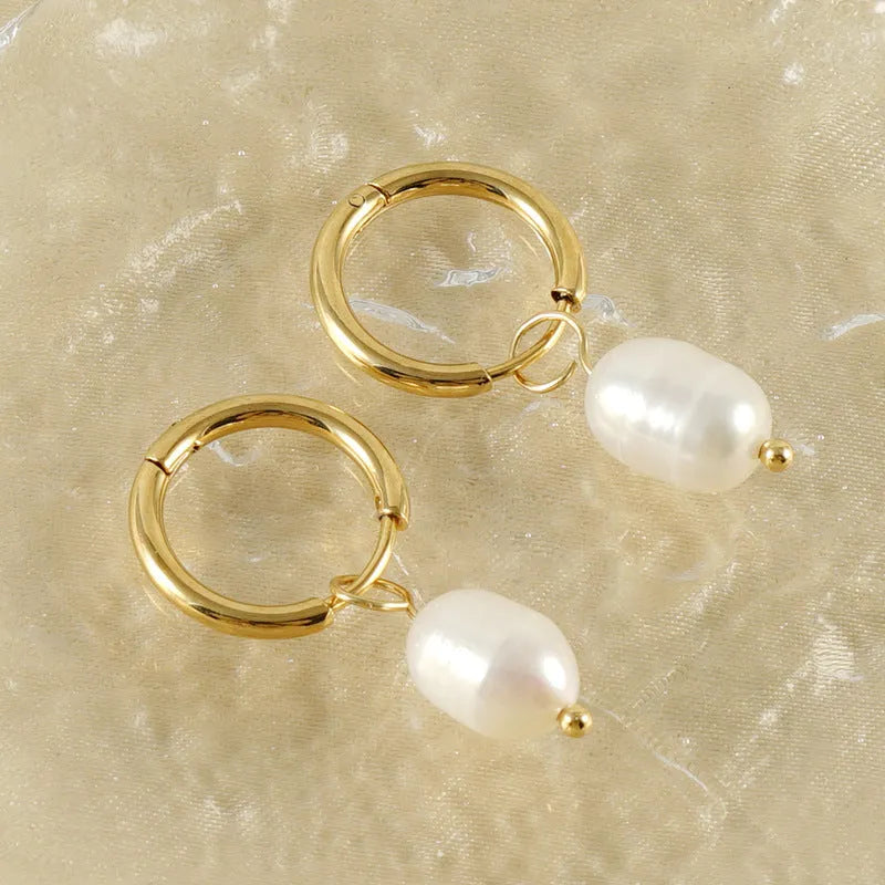 A pair of gold-coloured geometric stud earrings with a single pearl accent on each.