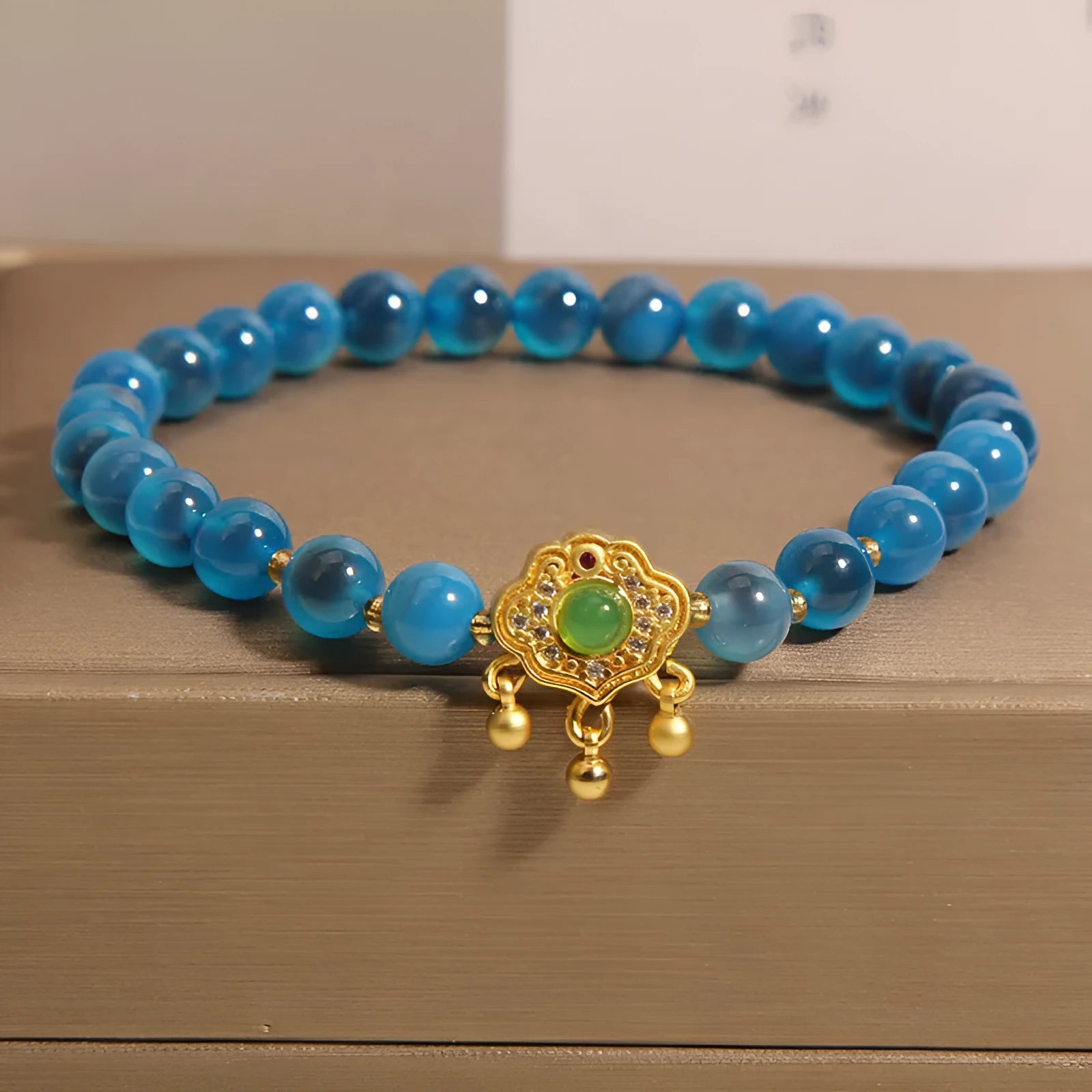 Blue agate safety lock pendant on a crystal women's bracelet with rhinestone details.