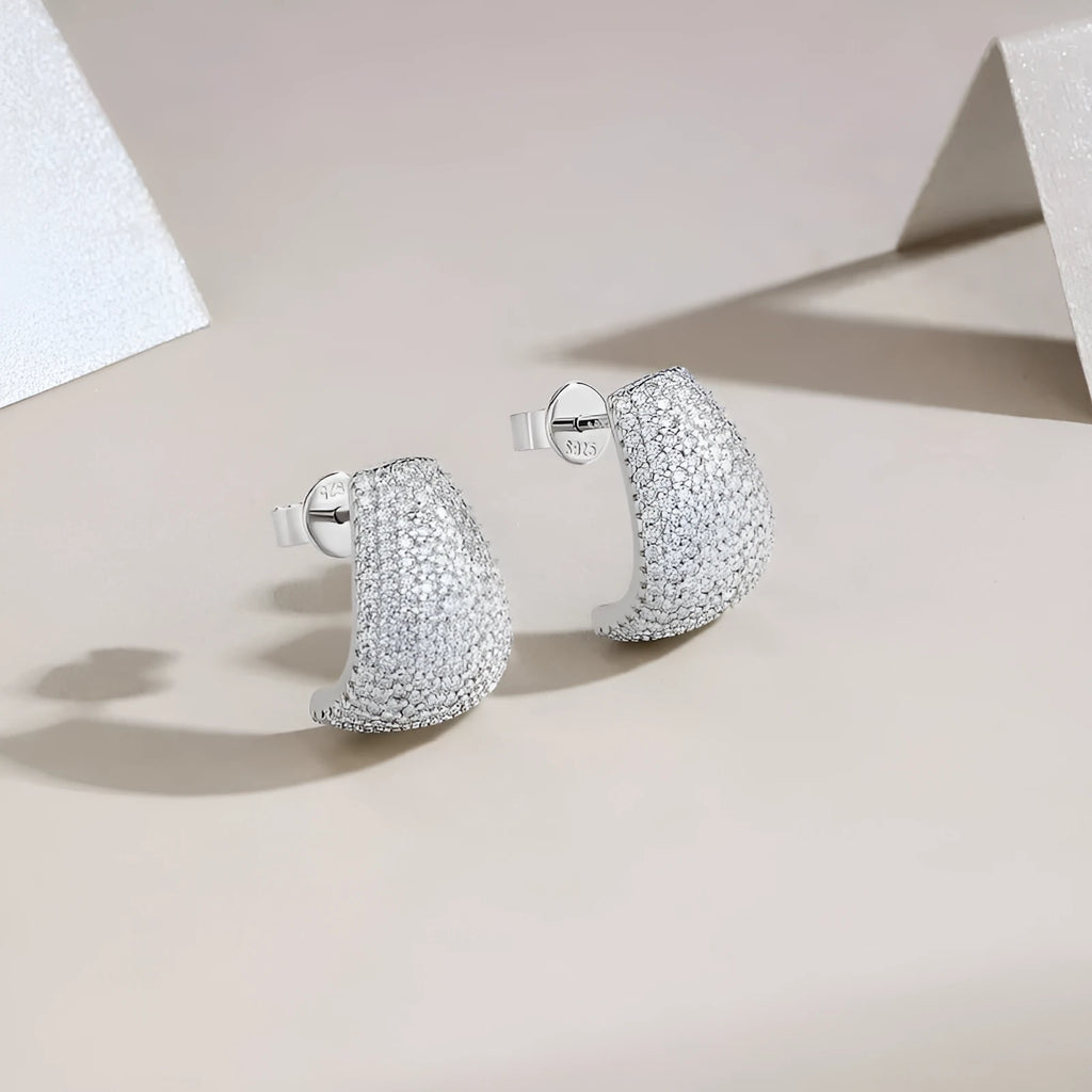 Geometric moissanite stud earrings with sterling silver posts on a gift box