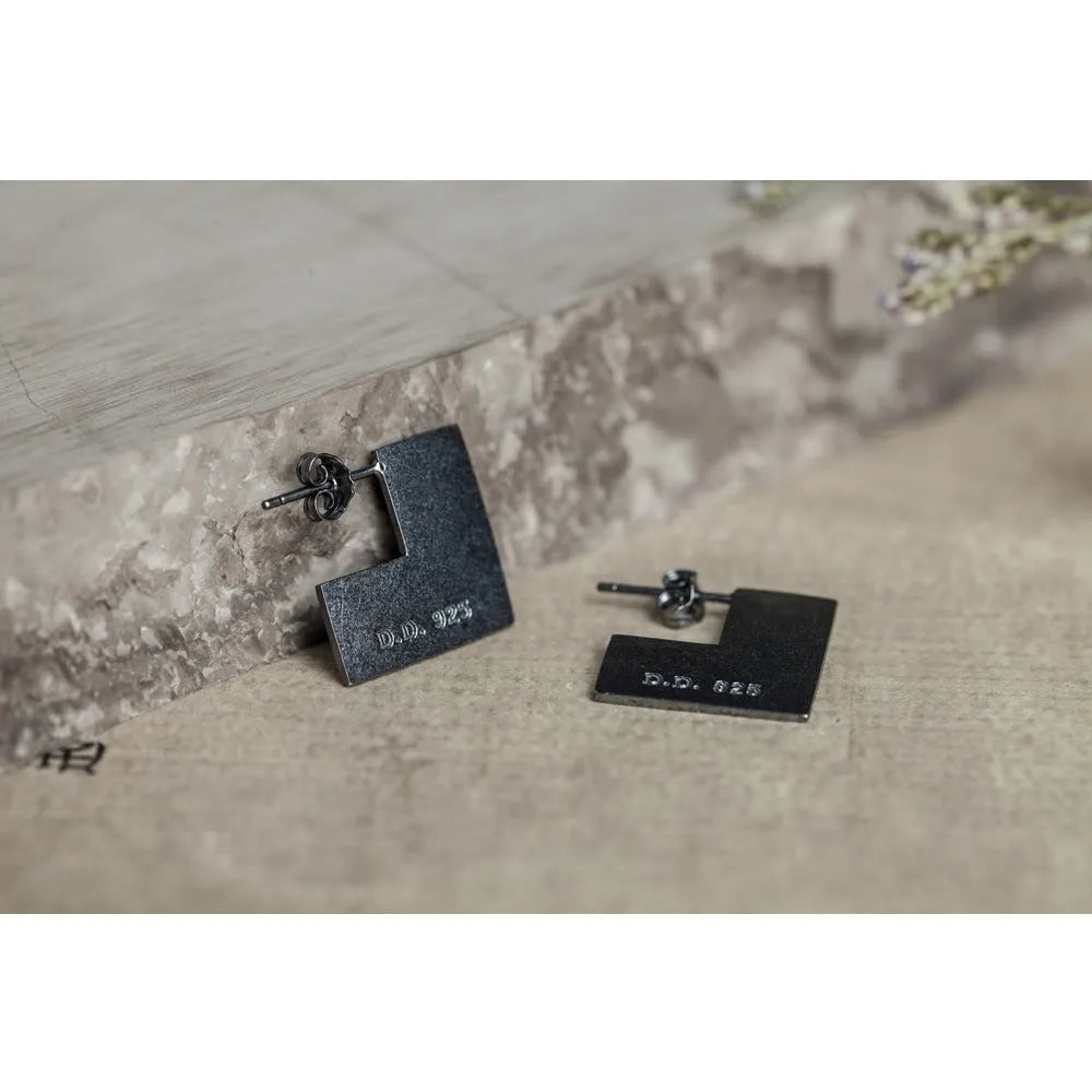 Square oxidised black sterling silver geometric earrings on a white background.