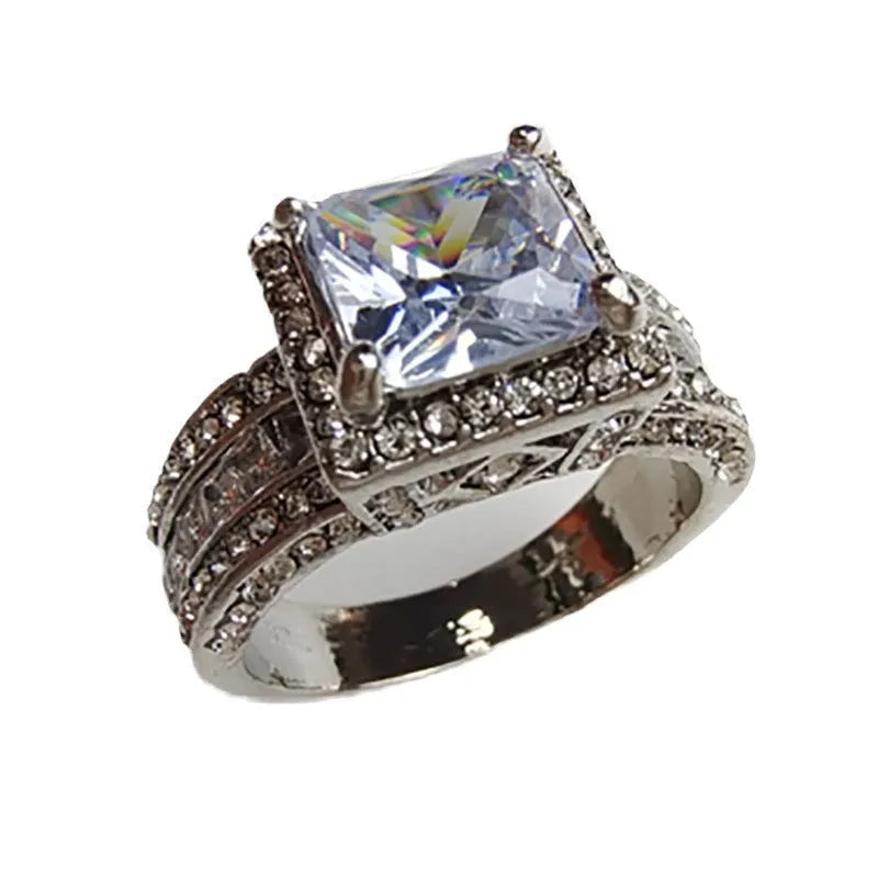 Women's silver geometric round ring in gold or white electroplated finish on a grey background