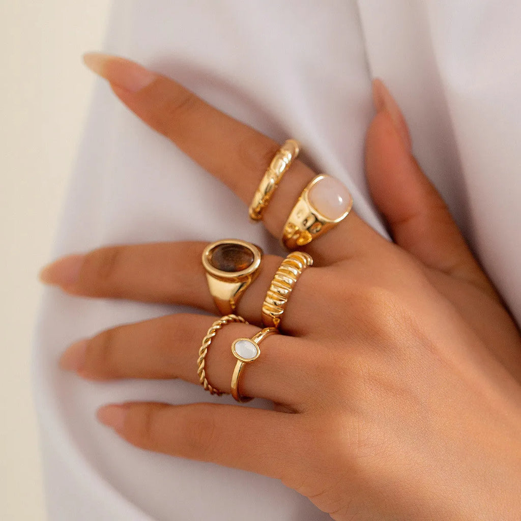 Six light gold geometric alloy rings with electroplated finish displayed together