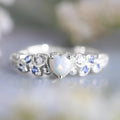 Women's white heart-shaped ring with floral and ocean opal design elements