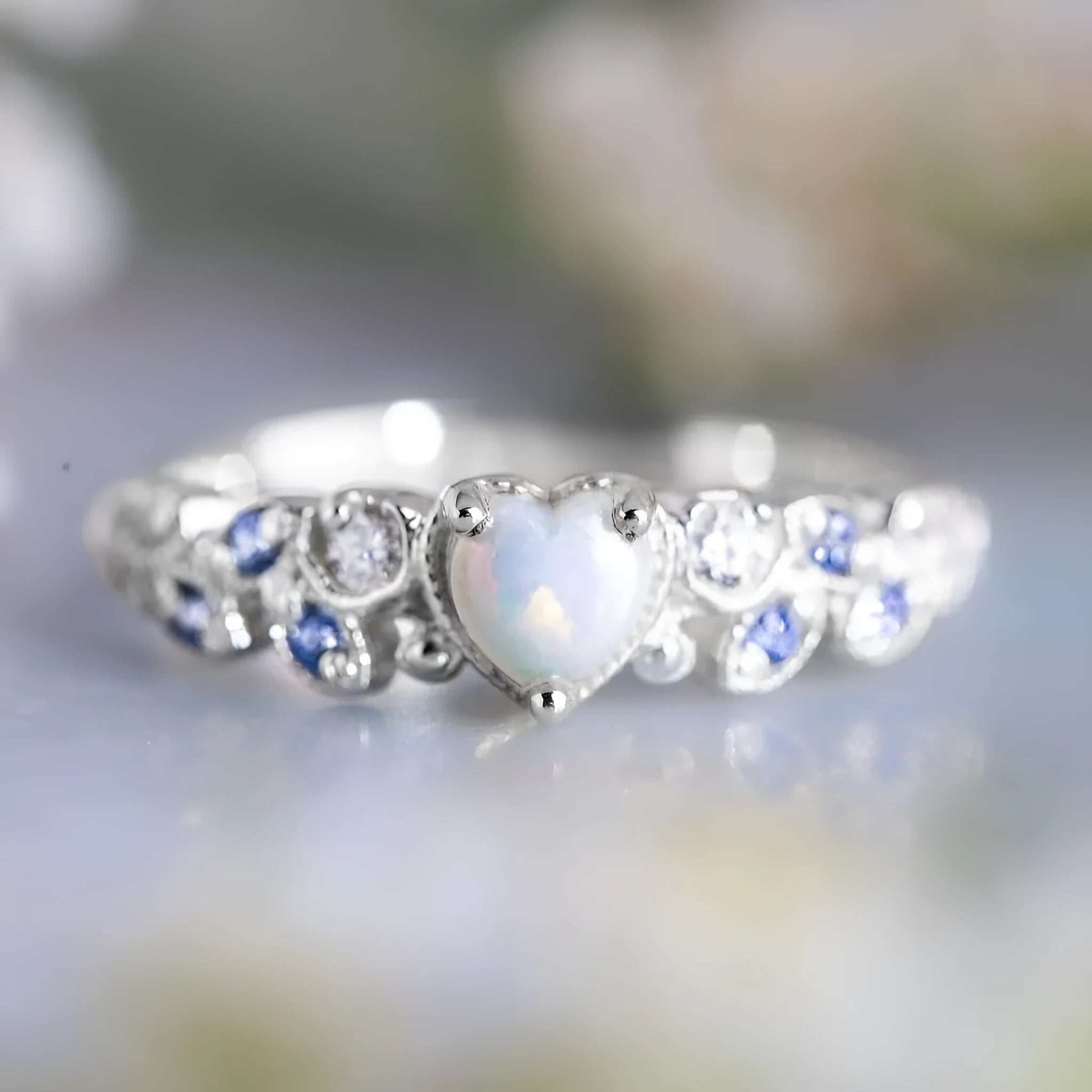Women's white heart-shaped ring with floral and ocean opal design elements