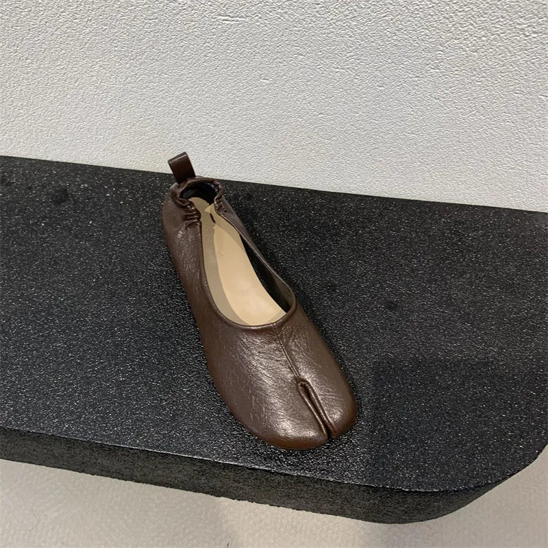 Women's brown split toe horseshoe design chunky heel pumps on a white background.