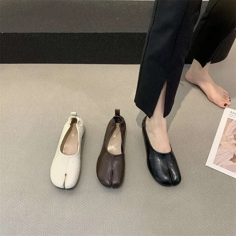 Women's brown split toe horseshoe design chunky heel pumps on a white background.
