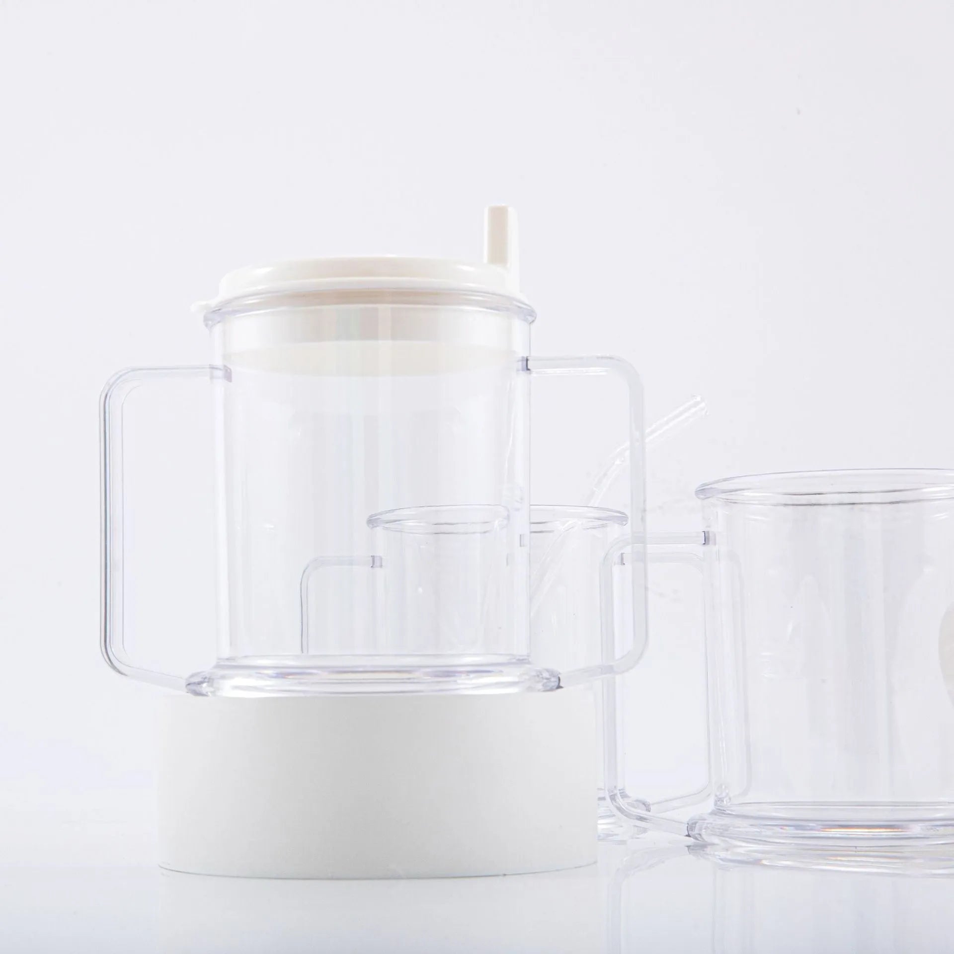 Transparent plastic drinking cup with a lid on a solid background.