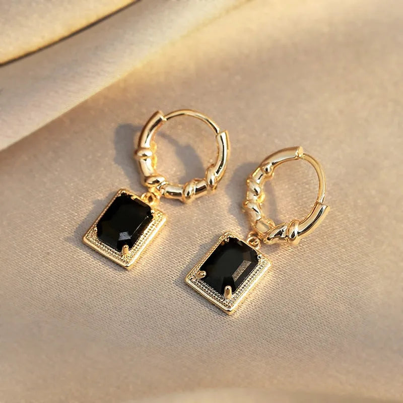 A pair of geometric black zircon earrings with a quadrilateral shape on a copper setting.