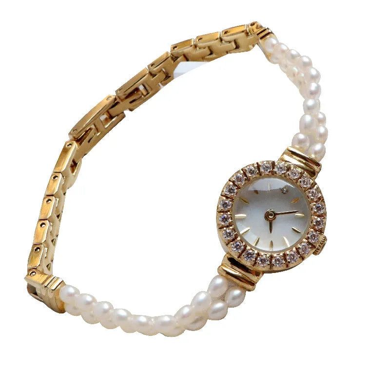 Light gold women's bracelet watch with freshwater pearls on stainless steel strap and round dial.