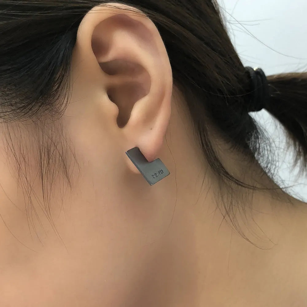 Square oxidised black sterling silver geometric earrings on a white background.
