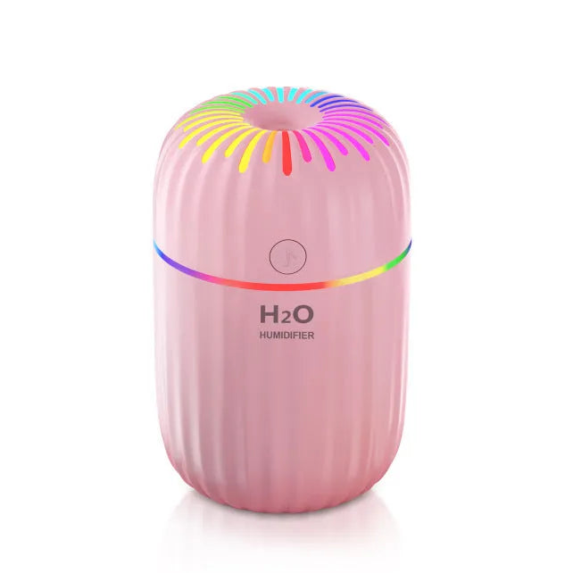 Mini car-shaped USB aromatherapy humidifier in green, pink, or white colours on a desk.