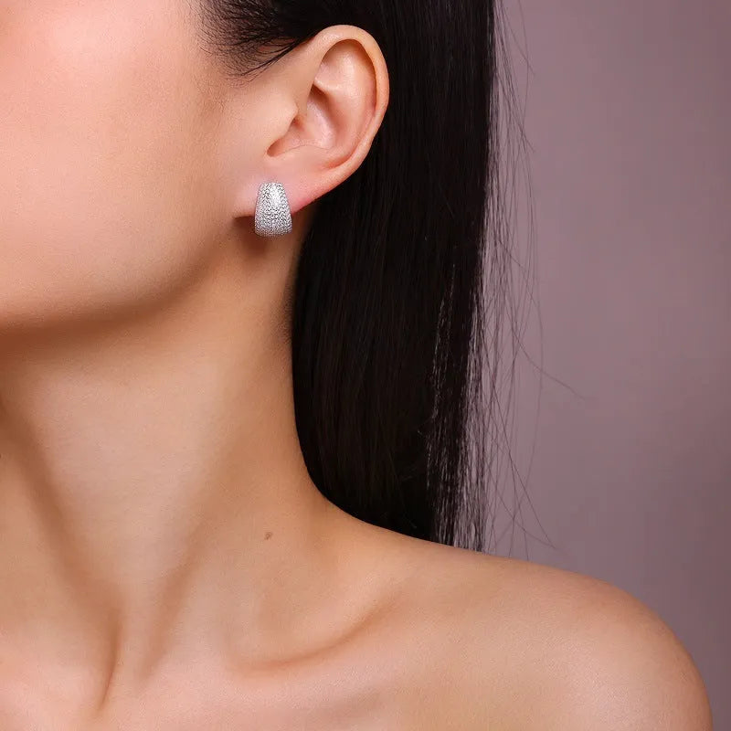 Geometric moissanite stud earrings with sterling silver posts on a gift box