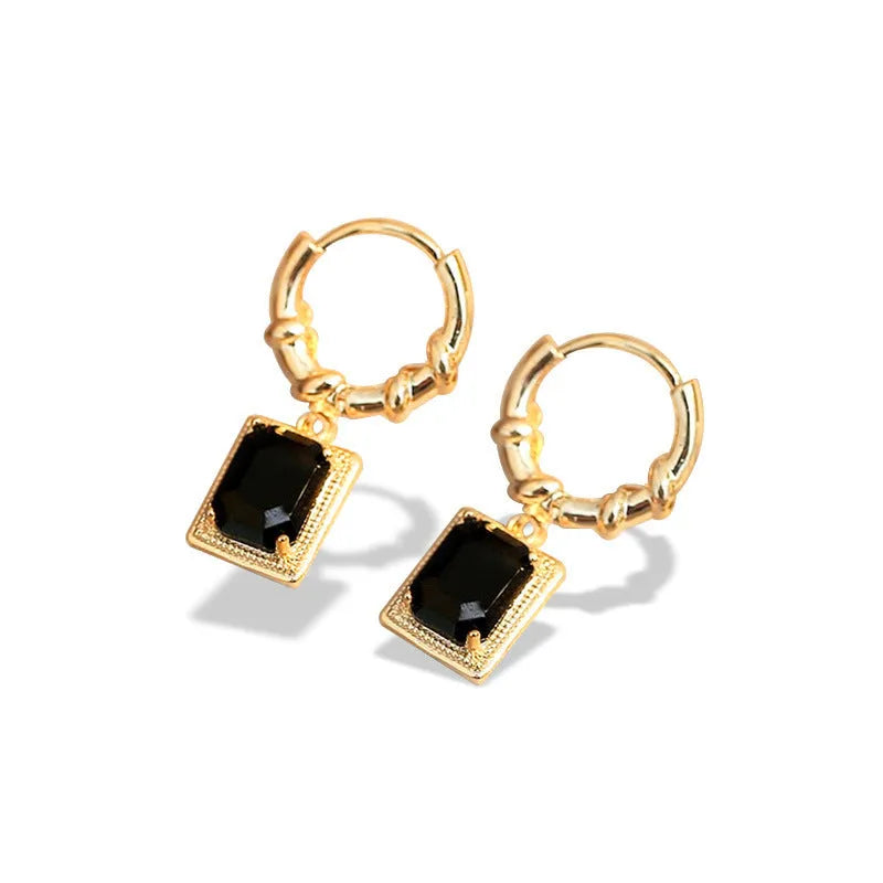 A pair of geometric black zircon earrings with a quadrilateral shape on a copper setting.