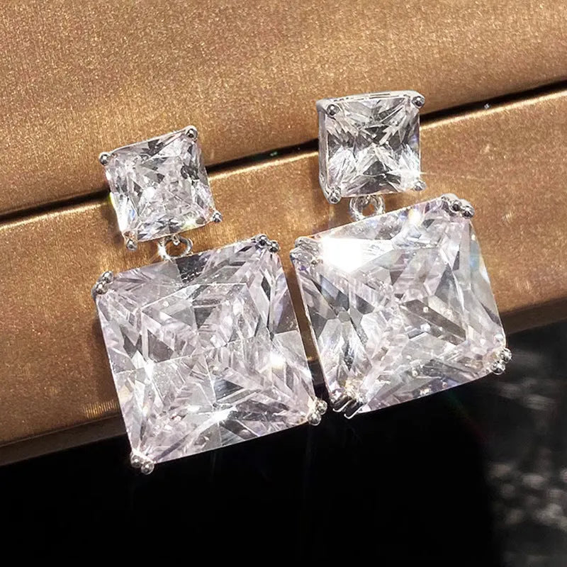 A pair of geometric square design copper earrings for women in gold and white gold colour options.