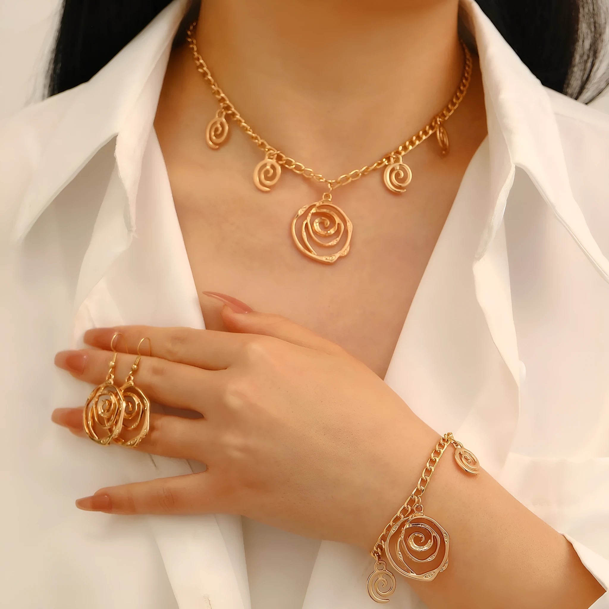 Gold spiral donut geometric jewellery set with adjustable necklace, matching bracelet, and earrings on a white background.