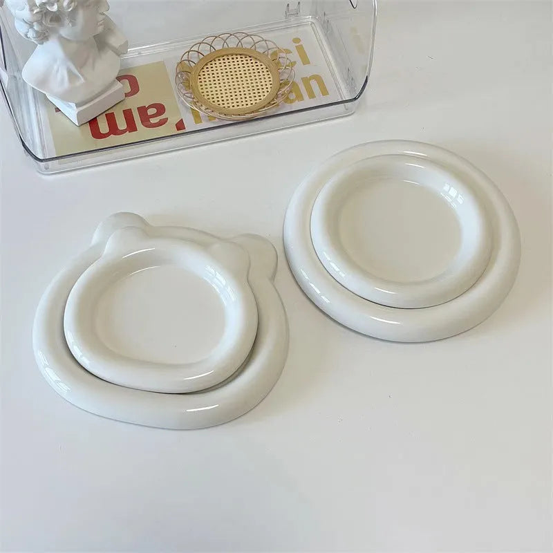 White porcelain plate with bear doodle design, shown as a plant pot tray.