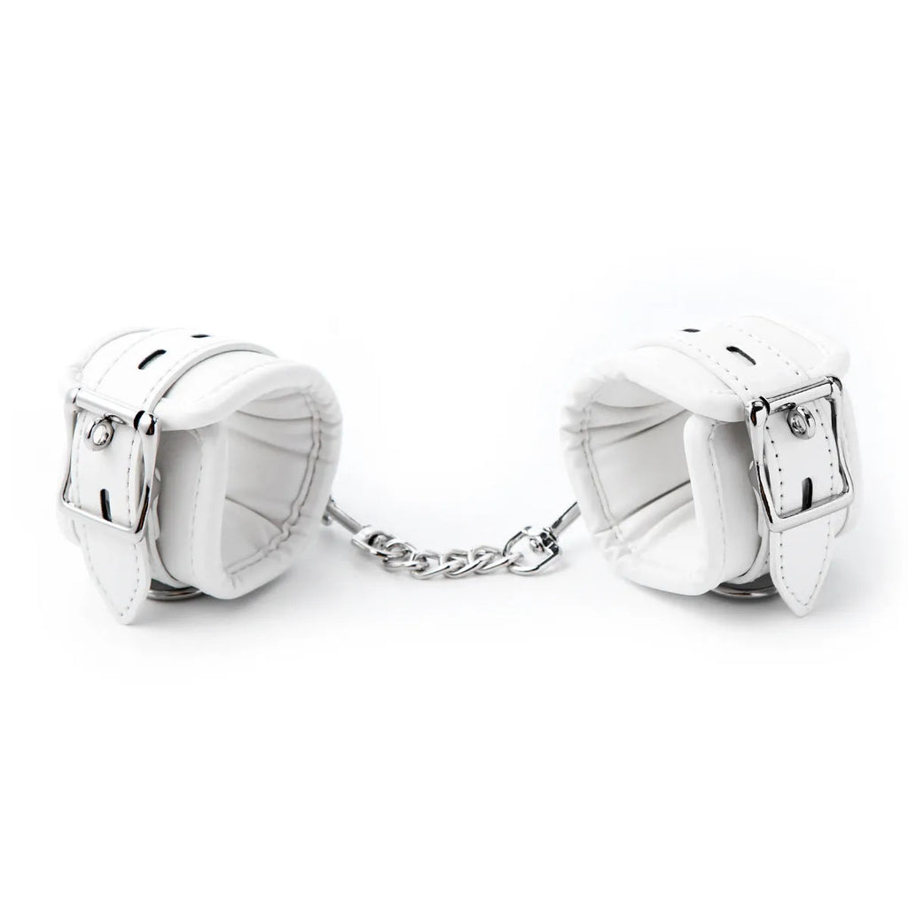 White PU sponge bondage set showing handcuffs, footcuffs, and a neck scarf arranged together.