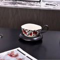 Antique style ceramic coffee cup and saucer set with medieval pattern in black or orange