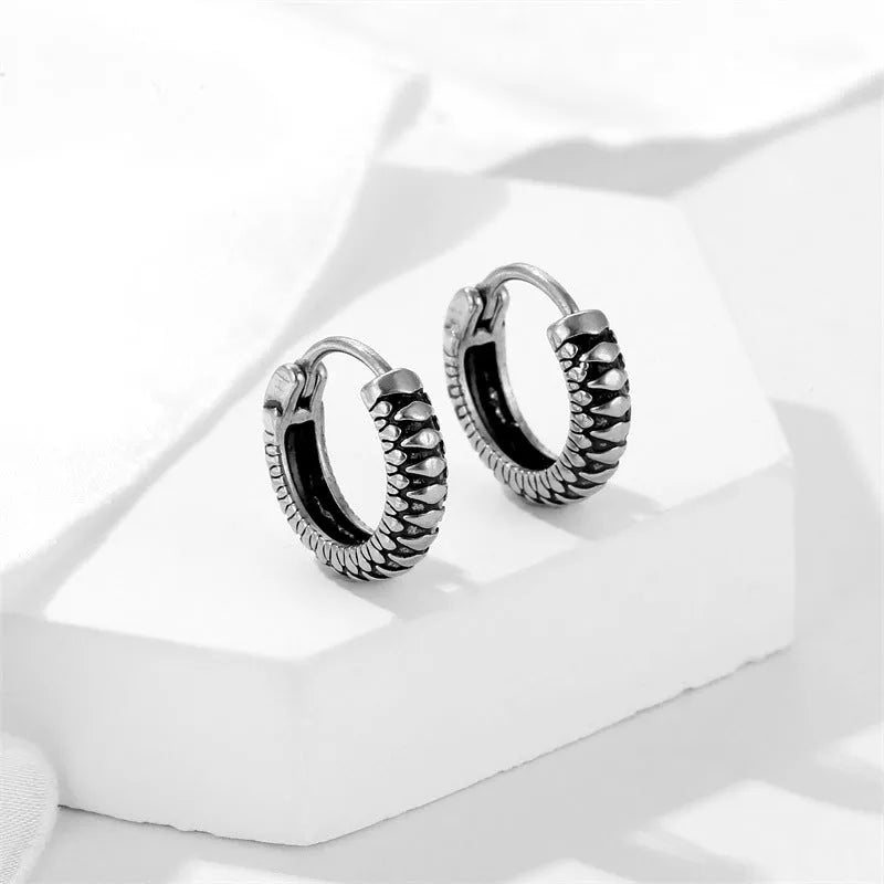 Silver geometric twist earrings with circular elements on white background