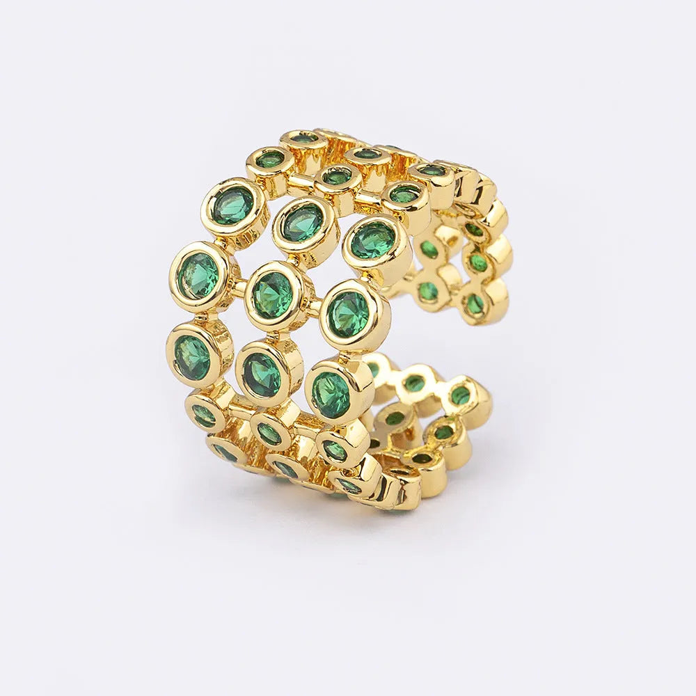 Gold-coloured wide ring with a textured three-layer exaggerated design on a plain background.