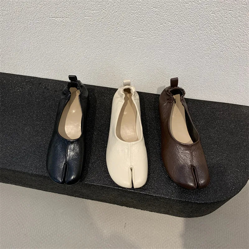 Women's brown split toe horseshoe design chunky heel pumps on a white background.