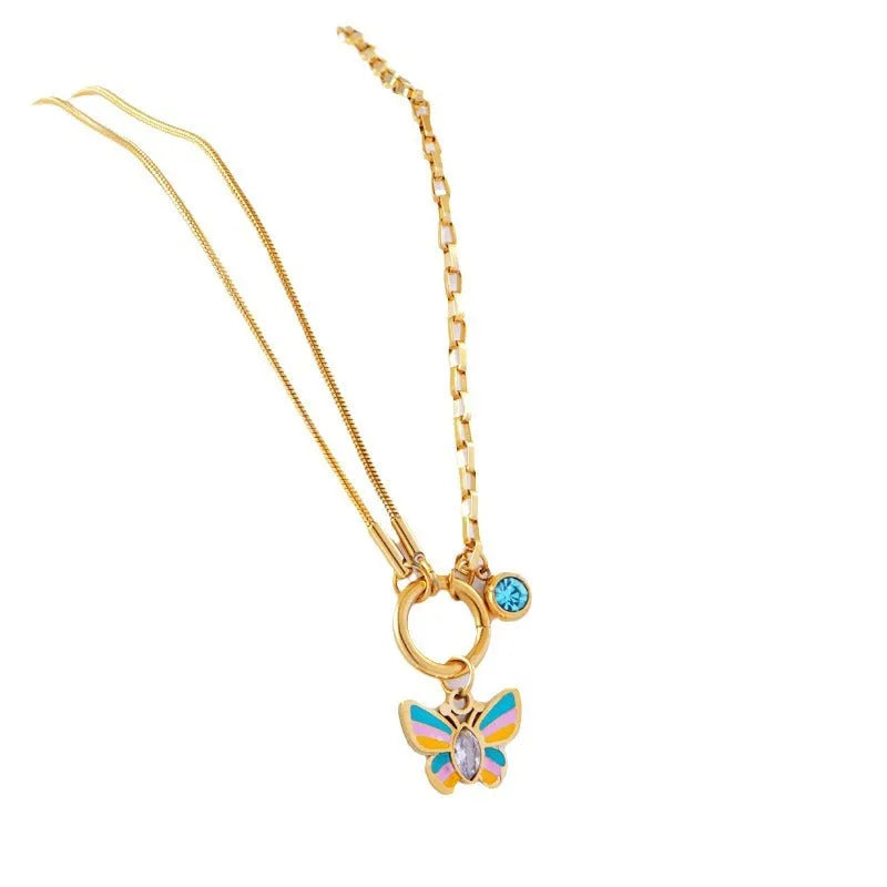 Gold titanium steel butterfly necklace and matching bracelet set on a dark background.