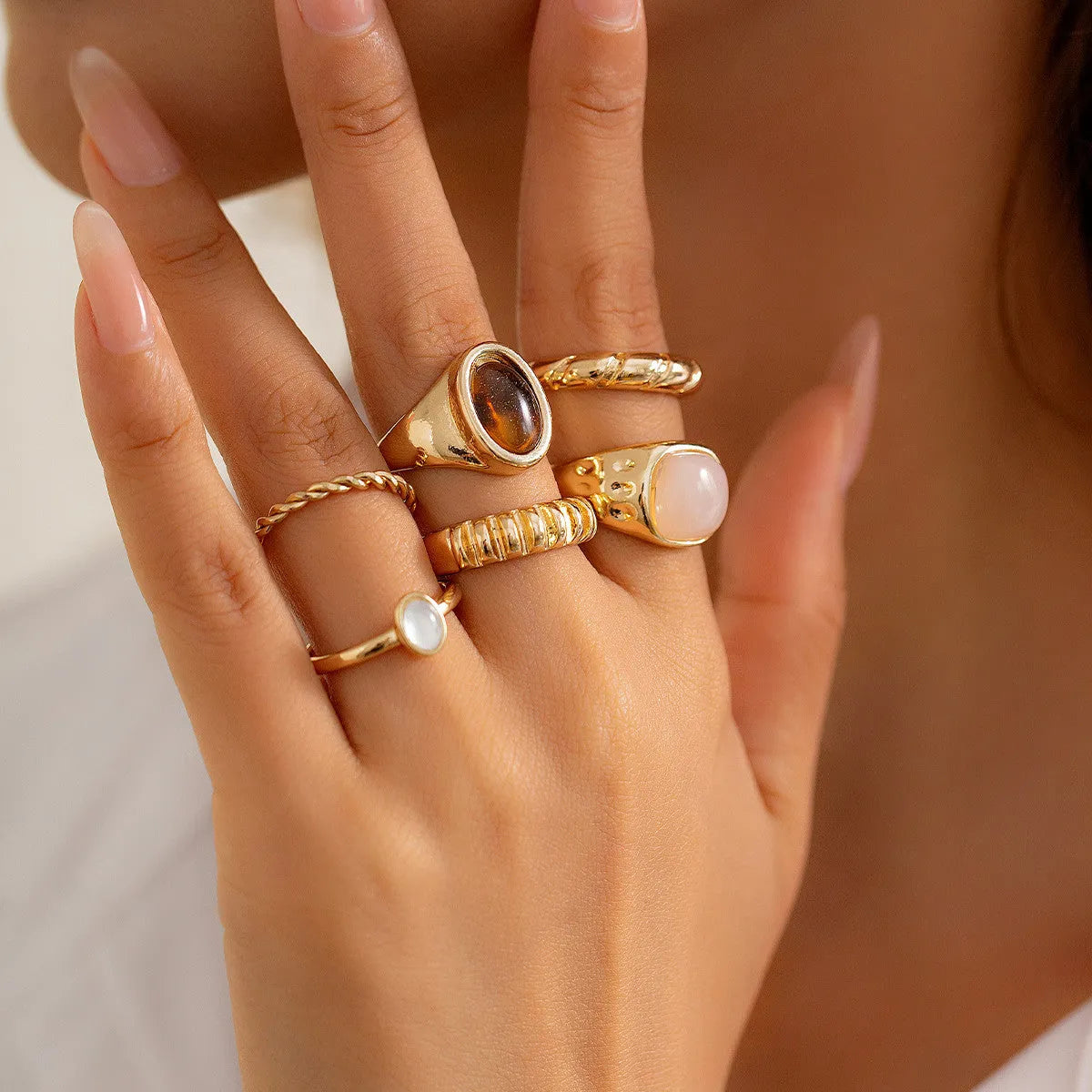 Six light gold geometric alloy rings with electroplated finish displayed together