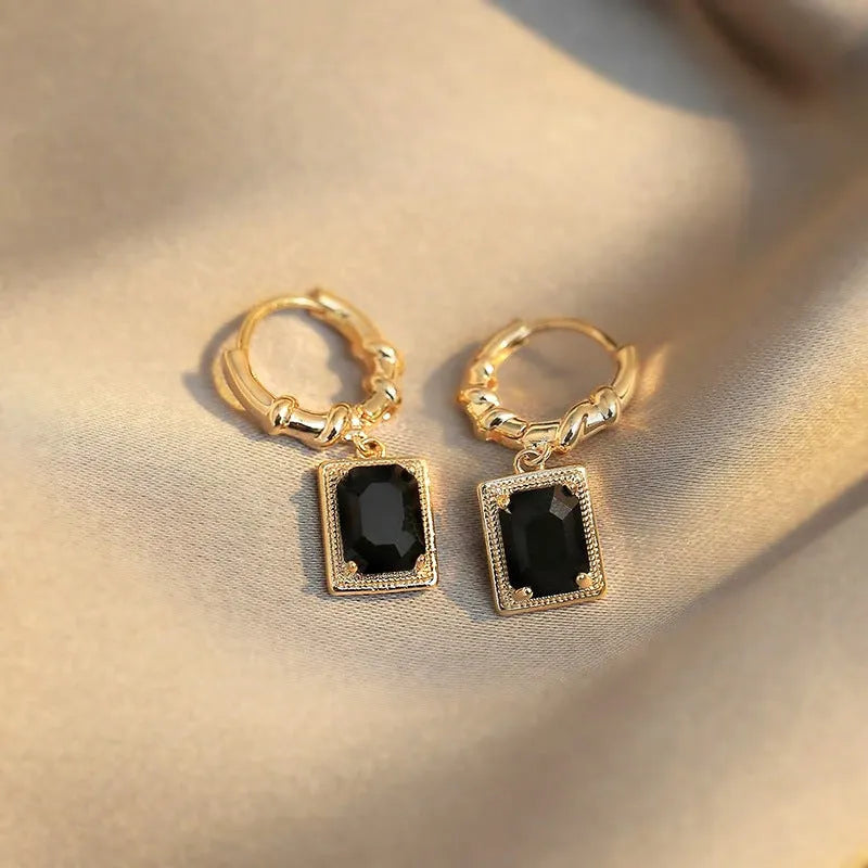 A pair of geometric black zircon earrings with a quadrilateral shape on a copper setting.