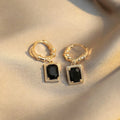 A pair of geometric black zircon earrings with a quadrilateral shape on a copper setting.