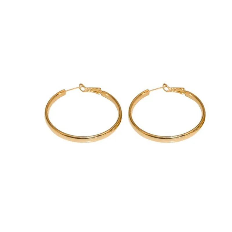 A pair of large 40mm gold metal circle hoop earrings on a white background.